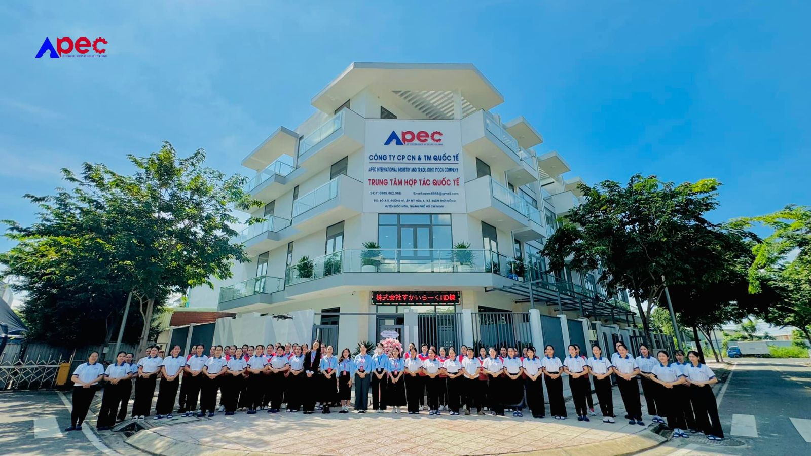 Toàn cảnh tòa nhà Apec với đội ngũ nhân viên và học viên đứng trước sảnh chính.