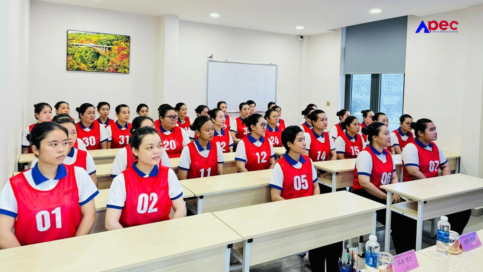 Học viên Apec trong trang phục đào tạo tập trung lắng nghe trong lớp học.