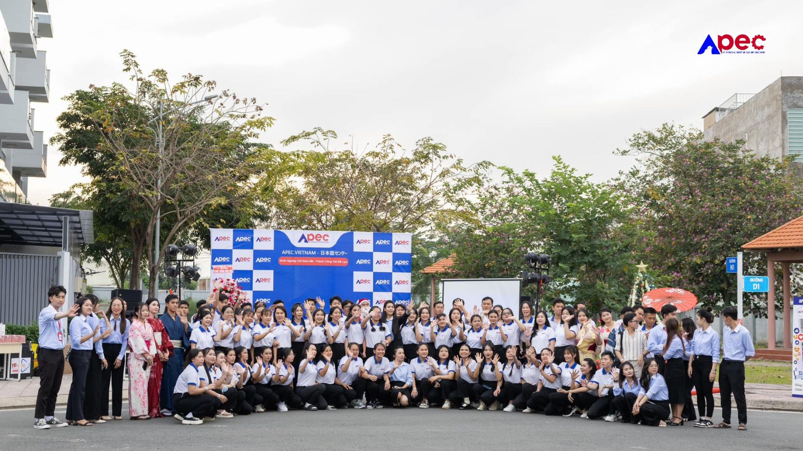 Đội ngũ và học viên Apec chụp ảnh tập thể ngoài trời, thể hiện sự gắn kết của cộng đồng.